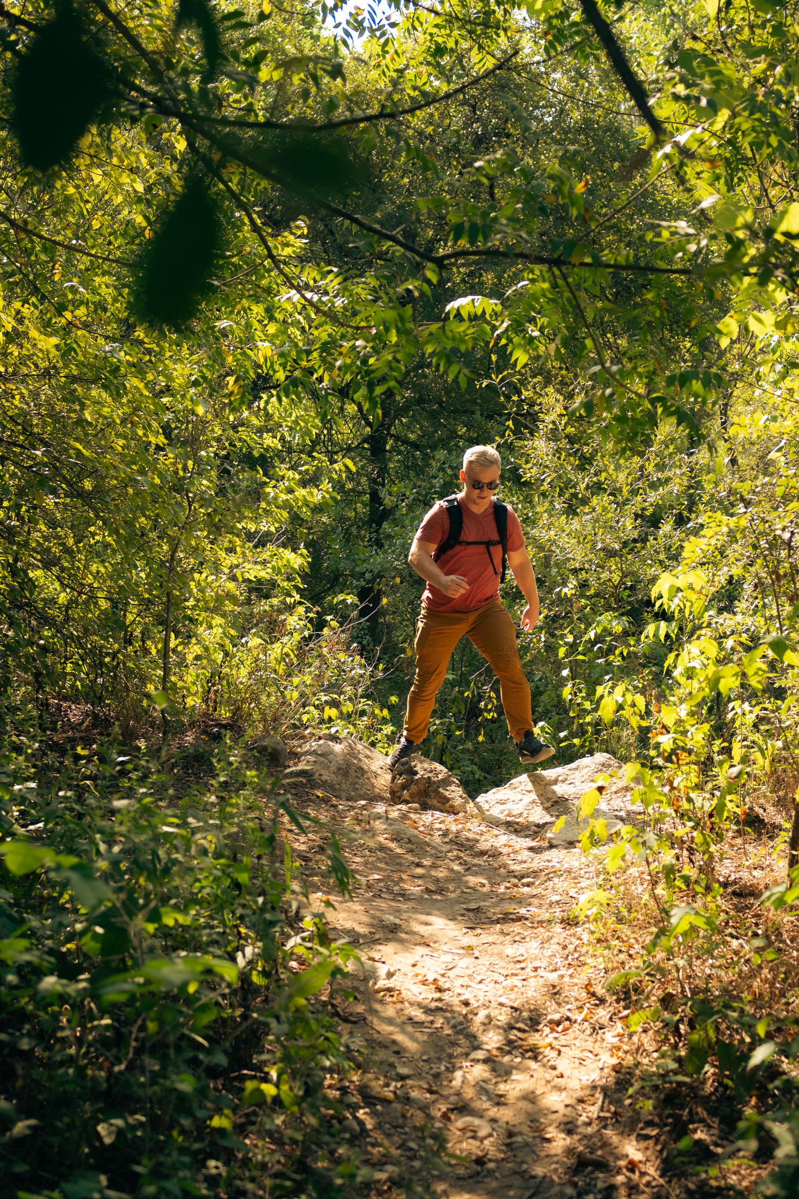 A man hiking through the trees near Barton Creek
