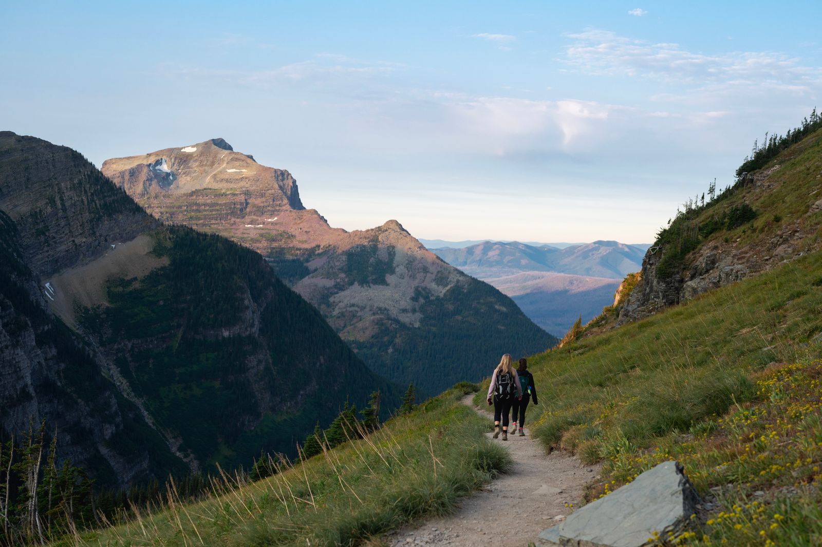 Hikers following a trail, with a mountain backdrop