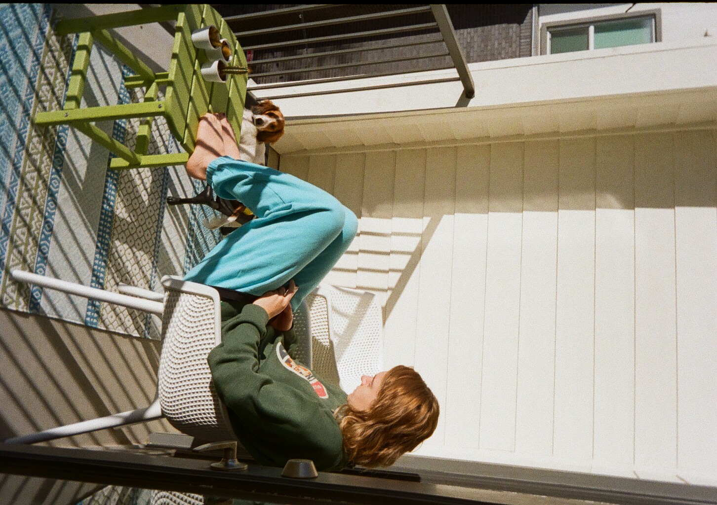 My wife and dog sitting on our balcony in the sunlight